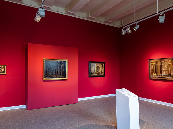 Rot gestrichener Ausstellungsraum mit Gemälden