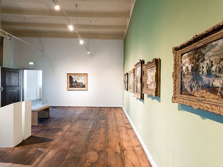 Großes goldgerahmtes Landschaftsgemälde an einer grünen Wand